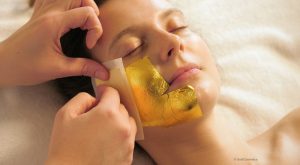 Applying cosmetic gold leaf on skin GoldCosmetica